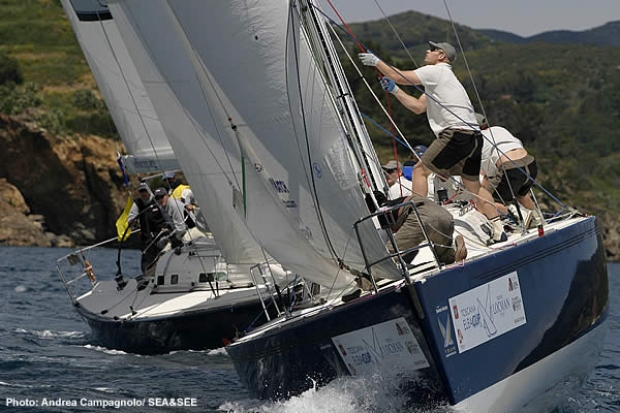 The Pizza-La Sailing Team hoists the spinnaker at a windward mark rounding during its quarterfinal match against Team Musto