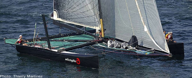 The all-carbon Alinghi catamaran weighs less than an Etchell. Bertarelli helms while the crew sit out to leeward
